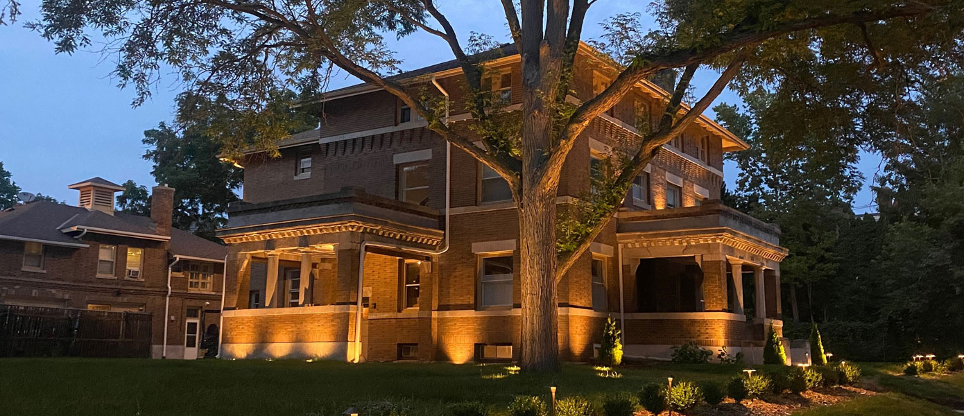 A large brick house with a tree in front of it